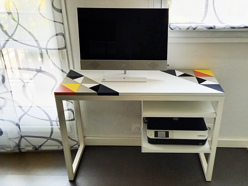 Bureau ordinateur design dessiné et fabriqué sur mesure avec un décor Origami associé à une structure blanche. Design Les Pieds Sur La table