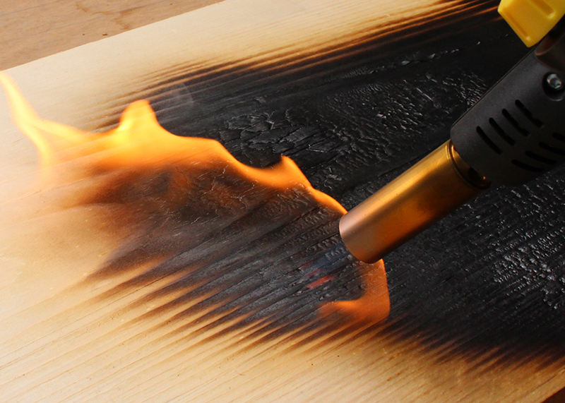 Finition bois brûlé technique shou sugi ban dans l'atelier de meubles design Les Pieds Sur La Table Paris