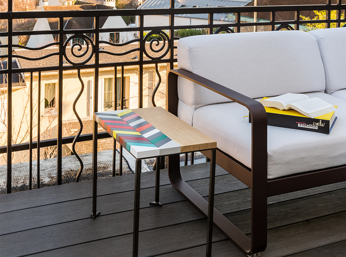 Table basse bois motif en couleurs Origami sur terrasse d'hiver. Collection Meubles Les Pieds Sur La Table