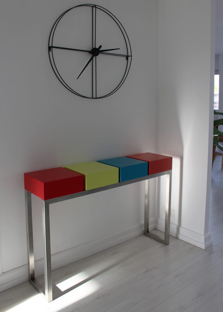 Console d'entrée Pied-Estal en inox et laque installée dans le séjour. Réalisation maison Les Pieds Sur La Table créateur de Mobilier contemporain et fabricant sur mesure