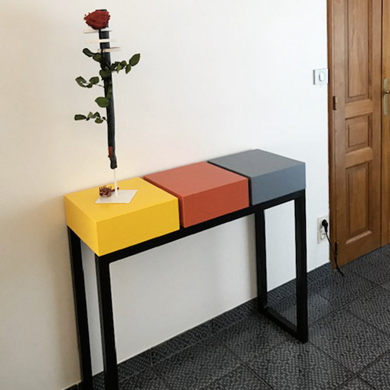 Console design sur mesure réalisée avec 3 cubes tiroirs laqués de couleurs solaires sur un pied en acier patiné. Console moderne d'entrée laquée Pied-Estal. Mobilier Les Pieds Sur La Table créateur et fabricant de meubles contemporains design sur mesure.