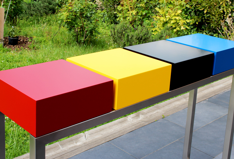 Console design connectée Plug&Pied sur mesure avec un choix de couleurs intenses : rouge piment, jaune soleil intense, bleu proche du cyan et noir sur un pied en inox brossé