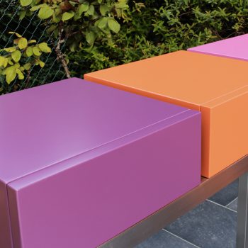 Console moderne décorative avec 3 tiroirs sur mesure à ouverture en façade. Console Pied-Estal avec un piétement en inox brossé. Tiroirs en couleurs finition laque contemporaine satinée, couleurs aubergine, orange pop, fuchsia. Photo détail. Une