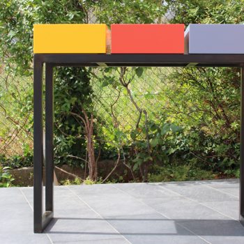 Console design sur-mesure pied en acier noir et cubes tiroirs laqués de couleurs jaune soleil, orange pop, gris béton. Console avec 3 tiroirs. Mobilier Les Pieds Sur La Table créateur et fabricant de meubles contemporains design sur mesure. Photo devant l'atelier