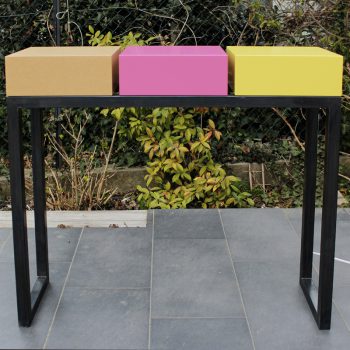 console design connectée avec alimetation électrique en atelier. Console sur mesure, structure en acier patiné, cubes laqués fuchsia, jaune lime et médium vernis. Console moderne Plug&Pied Mobilier design modulable Les Pieds Sur La Table