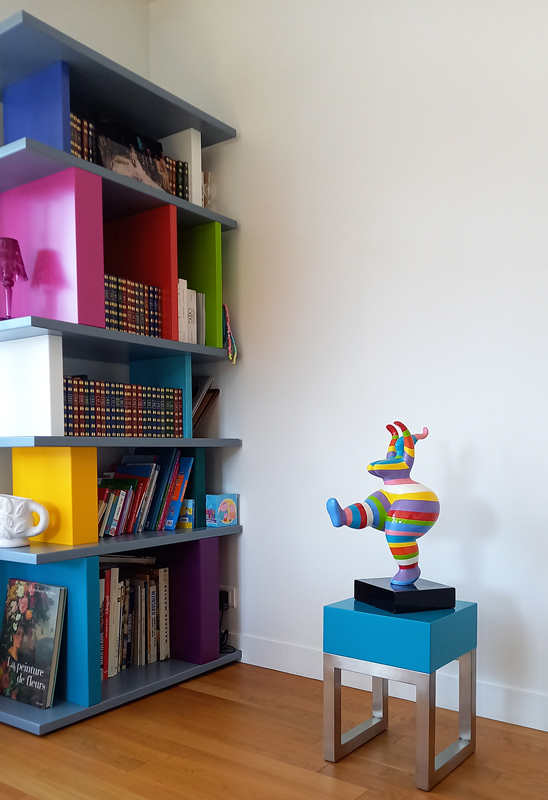 Le socle design en inox brossé et bois laqué turquoise est coordonné à la sculpture et à la bibliothèque Tu-Lis-Pied adjacente. Création mobilier contemporain Les Pieds Sur La Table